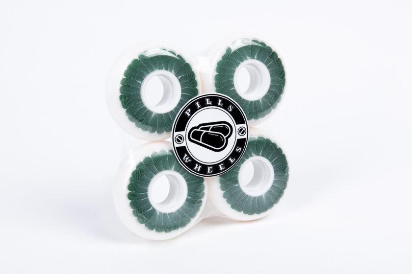 White Polyurethane 64 mm Wheels with White Cores, Tinted Green Flower, Grey Linocut Outlines Design and Black and White Pills Wheels Logo