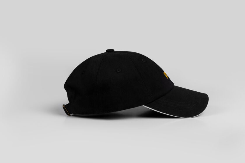 black cap with yellow blackletter embroidery and white sandwich sideview