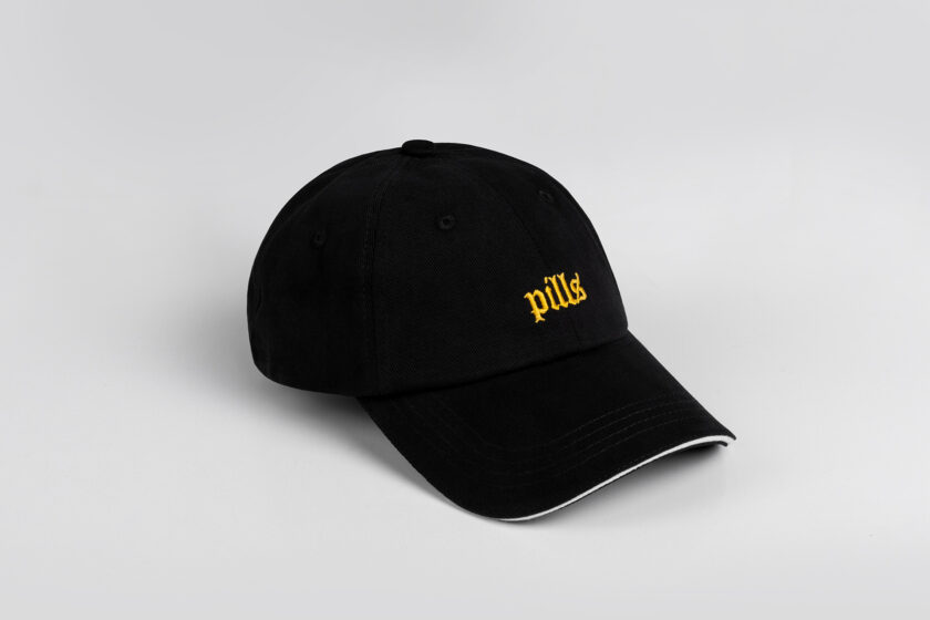 black cap with yellow blackletter embroidery and white sandwich isometry